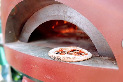 Pizza Dishes Being Prepared in Stone Oven