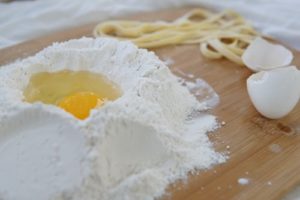 Ingredients on a wooden board for making fresh pasta